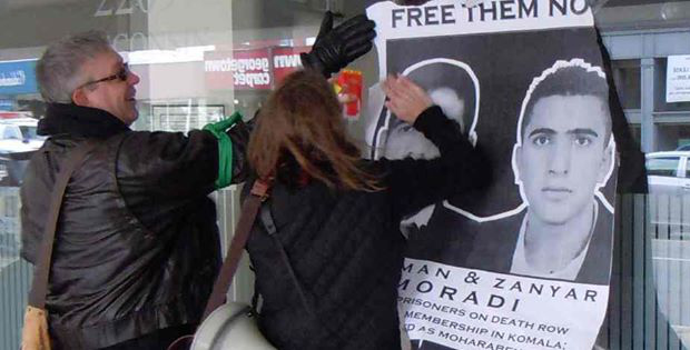 Couples attach a banner calling for the release of Zanyar and Loqman in Europe