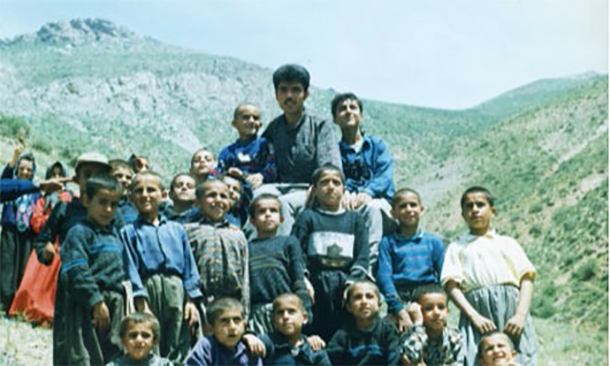 Kurdish teacher Ferzad Kemanger surrounded by his pupils in the Kurdistan region